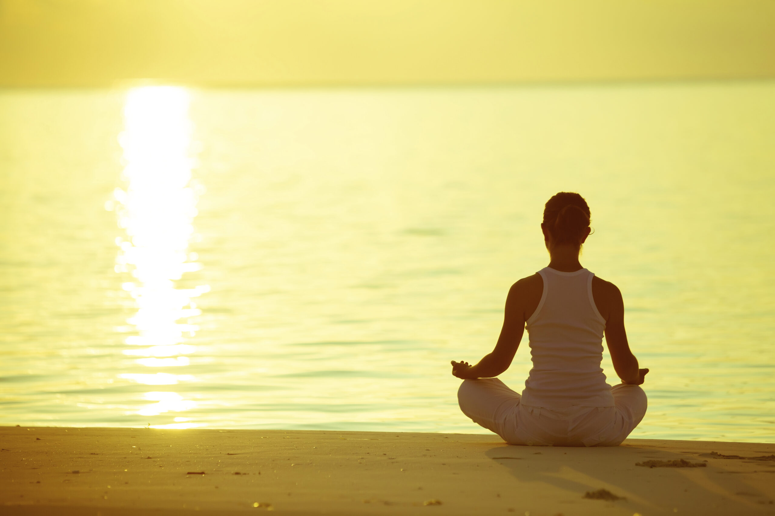 Caucasian woman practicing yoga at seashore